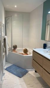 a woman sitting in a bath tub in a bathroom at LE CHOUCAS - LA MONGIE in Bagnères-de-Bigorre +27 photos