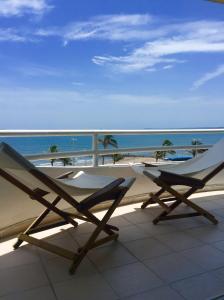 a pair of chairs sitting on a balcony overlooking the ocean at Apartamento vista al mar in Boca del Río