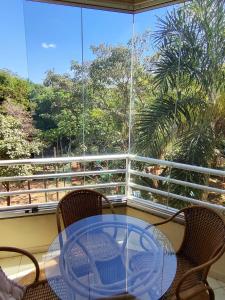 a glass table and chairs on a balcony at Thermas Paradise in Rio Quente