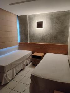 a hospital room with two beds and a window at Thermas Paradise in Rio Quente