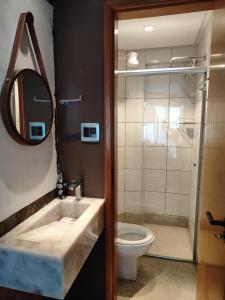 a bathroom with a sink and a toilet and a mirror at Thermas Paradise in Rio Quente