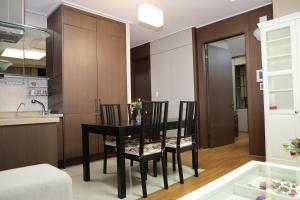 a kitchen and dining room with a black table and chairs at Highvill Apartments in Astana