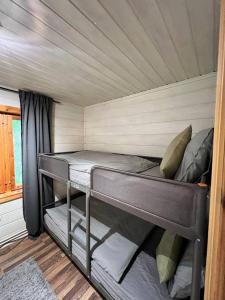 ein Zimmer mit Etagenbett in einem winzigen Haus in der Unterkunft Gemuetliches Blockhaus im Wald in Auktsjaur