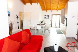 ein Wohnzimmer mit einem roten Sofa und einem Tisch in der Unterkunft In Love 01 in Montichiari