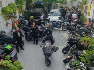 um grupo de motocicletas estacionado ao lado de um grupo de pessoas em Zigana Apartments em Mostar