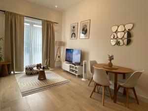 uma sala de estar com uma mesa e uma televisão em Luxury 2 bedroom Flat Sutton em Sutton
