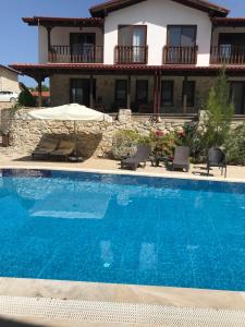 a swimming pool in front of a house at Rustic Modern Patio Home With Shared Pool in Kırıkyayla