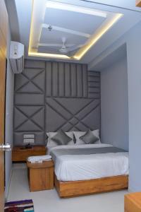 a bedroom with a large bed with a large headboard at Hotel Green Park in Gandhinagar