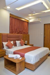 a bedroom with two beds and a table at Hotel Green Park in Gandhinagar