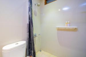 uma casa de banho com um chuveiro, um WC e um lavatório. em Payu Hotel Jogja em Jetis