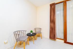 Duas cadeiras e uma mesa num quarto com uma janela em Payu Hotel Jogja em Jetis