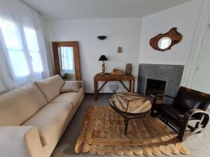 uma sala de estar com um sofá, uma cadeira e uma lareira em Villa "Les Flots en Ré" em La Flotte
