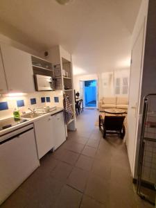 uma cozinha com electrodomésticos brancos e uma sala de estar em Villa "Les Flots en Ré" em La Flotte
