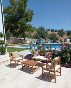 een patio met stoelen, een tafel en een zwembad bij Dervise Mehmet Guest House in Lefke-Karadağ