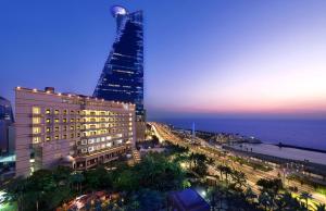 vistas a una ciudad con un edificio alto por la noche en Waldorf Astoria Jeddah - Qasr Al Sharq en Yeda