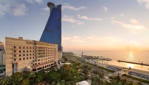 un alto edificio vicino a una spiaggia con l'oceano di Waldorf Astoria Jeddah - Qasr Al Sharq a Gedda