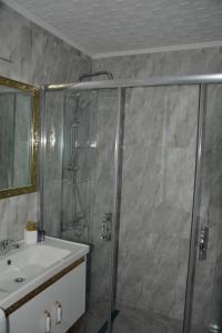 a bathroom with a shower and a sink at Hera Emlak in Kırac