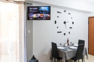 ein Esszimmer mit einem Tisch und einem TV an der Wand in der Unterkunft C3 Modern Spartan Apartment in Sparta