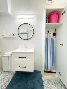 a white bathroom with a sink and a mirror at lovely apartment in Ra'anana in Ra‘ananna