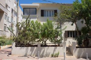 un edificio blanco con árboles delante de él en lovely apartment in Ra'anana en Ra‘ananna