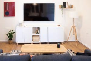 una sala de estar con un armario blanco con TV. en lovely apartment in Ra'anana en Ra‘ananna