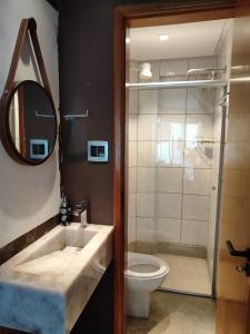 a bathroom with a sink and a toilet and a mirror at Thermas Paradise in Rio Quente