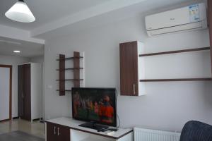 un soggiorno con TV a schermo piatto a parete di Hera Emlak a Kırac