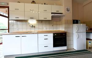 a kitchen with white cabinets and a white refrigerator at Holiday Home Vukovic in Saborsko