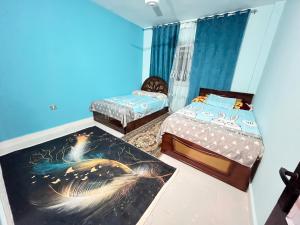 - 2 lits dans une chambre aux murs bleus dans l'établissement قرية منيه فايد بكسفريت, 
