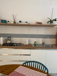 a kitchen with a stove and a sink and a table at La Casa di Mina in Monte di Procida