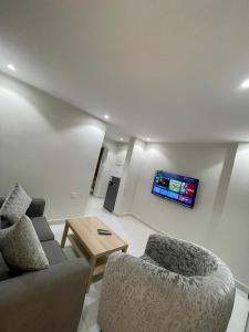 شقق جيهان الخاصة في المدينة المنورة: غرفة معيشة مع أريكة وكرسيين وتلفزيون