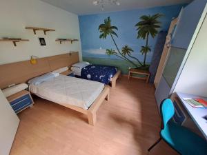 1 Schlafzimmer mit 2 Betten und einem Gemälde von Palmen in der Unterkunft La casa de riki 