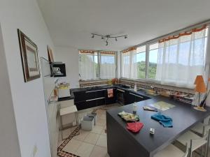 eine Küche mit einer Theke, einem Tisch und einigen Fenstern in der Unterkunft La casa de riki 