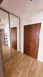 pusty pokój z drzwiami i drewnianą podłogą w obiekcie Apartament Młynarska w mieście Piła