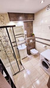 łazienka z umywalką i pralką w obiekcie Apartament Młynarska w mieście Piła