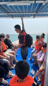 a group of people sitting on a boat at Turtle Guest House in Sur