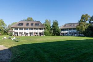 a large house with a large lawn in front of it at Seepark Weiden - Baumhof in Weiden am See