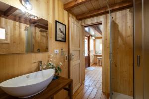 baño con lavabo blanco y paredes de madera en I Sicomori - Seme di Carota - Glamping e appartamenti con piscina a Saturnia, en Saturnia