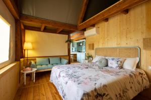 a bedroom with a bed and a couch in a room at I Sicomori - Seme di Carota - Glamping e appartamenti con piscina a Saturnia in Saturnia