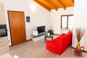 a living room with a red couch and a television at In Love 01 in Montichiari