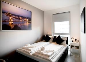 ein Schlafzimmer mit einem Bett mit einem Bild an der Wand in der Unterkunft SuiteAngel - Luxury Design Condo with free garage in Budapest
