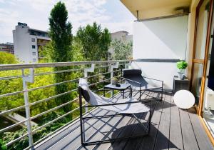 einen Balkon mit Stühlen und Tischen auf einem Gebäude in der Unterkunft SuiteAngel - Luxury Design Condo with free garage in Budapest