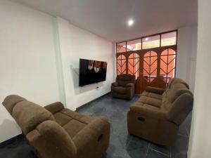 ein Wohnzimmer mit 2 Sofas und einem Flachbild-TV in der Unterkunft Casa Hospedaje Cajamarca in Cajamarca