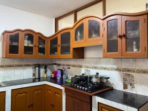 a kitchen with wooden cabinets and a stove top at Casa Hospedaje Cajamarca in Cajamarca