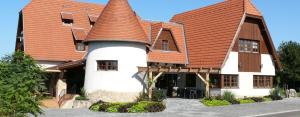 ein großes Haus mit orangefarbenem Dach in der Unterkunft Kádárta Vendéglő Panzió in Veszprém