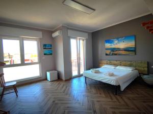 a bedroom with a bed and two windows at The House of the Waves in Brindisi