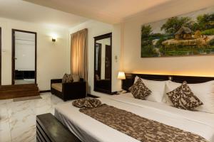 a hotel room with a bed and a couch at Cafe Aroma Inn in Kandy