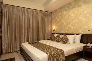 Habitación de hotel con cama y teléfono en Cafe Aroma Inn, en Kandy