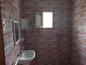 a pink bathroom with a sink and a window at Comfort house 