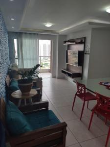 - un salon avec un canapé et une table dans l'établissement Quartos - Cíntia, à Fortaleza
